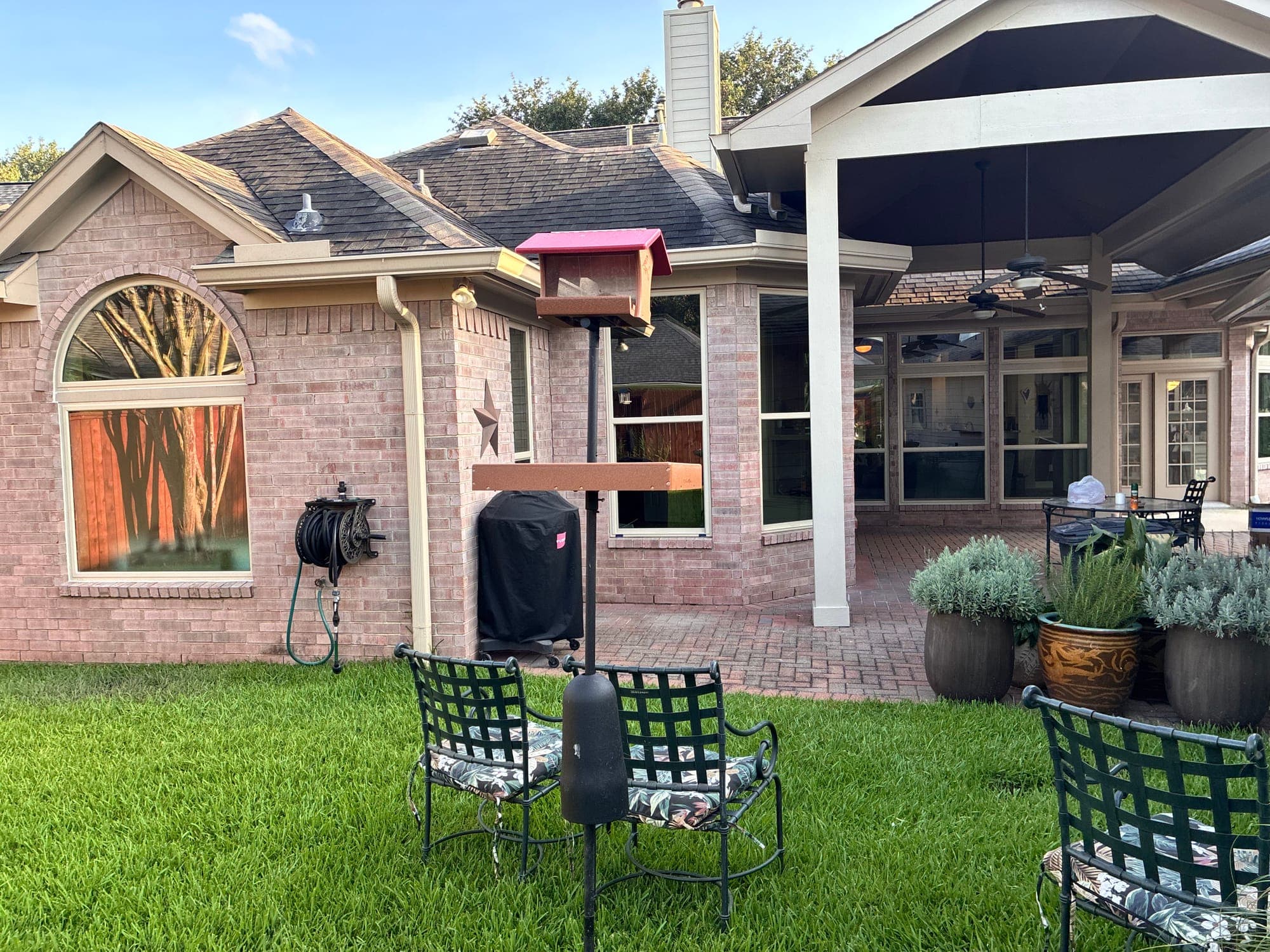 Pink-brick backyard elevation with a large almond-framed arch-top window