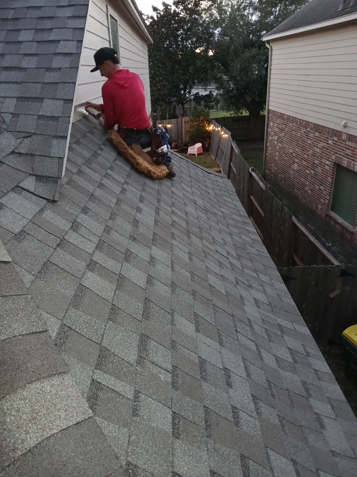 Bluebonnet roofer detailing sidewall flashing on a freshly installed architectural shingle roof
