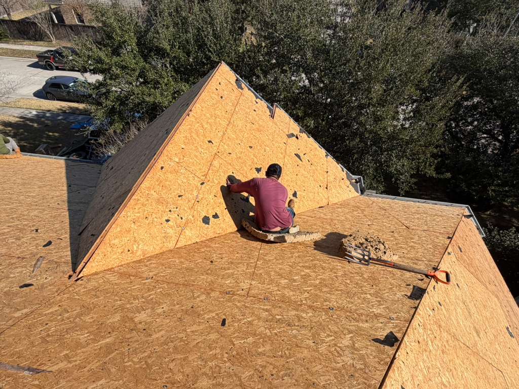 Roofer fastening OSB decking on a steep gable