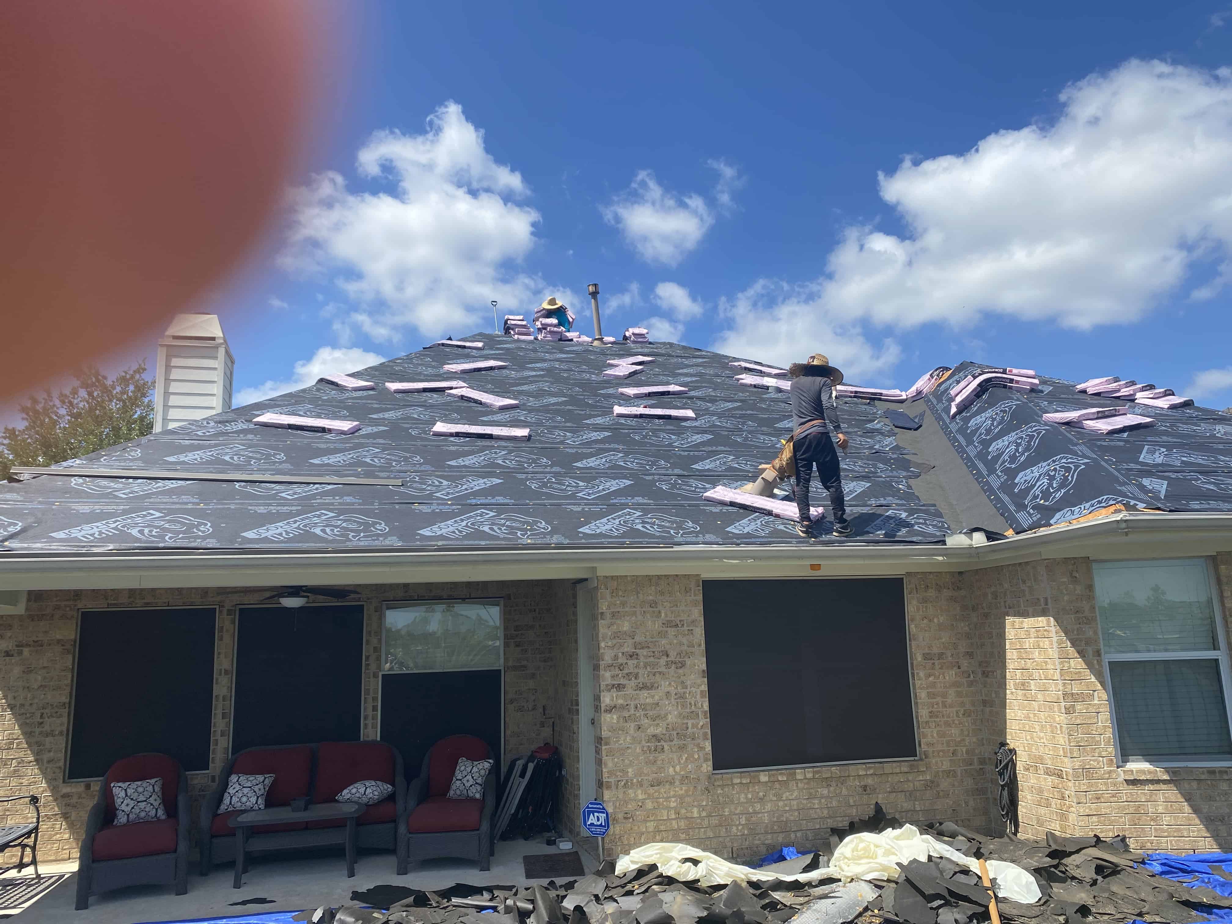 Brick home mid re-roof with a Bluebonnet crew working the front slope