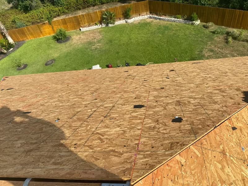Bluebonnet crew loading and staging shingle bundles on a residential roof