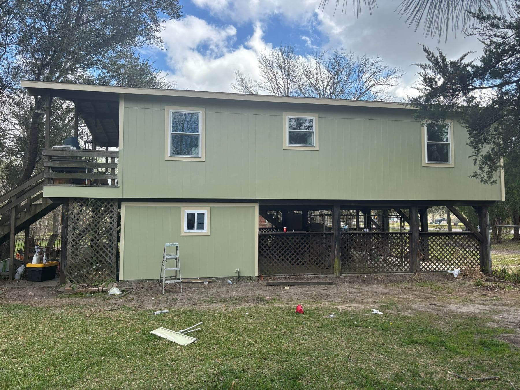 Rear elevation of the re-sided sage-green house with new cream-trimmed windows