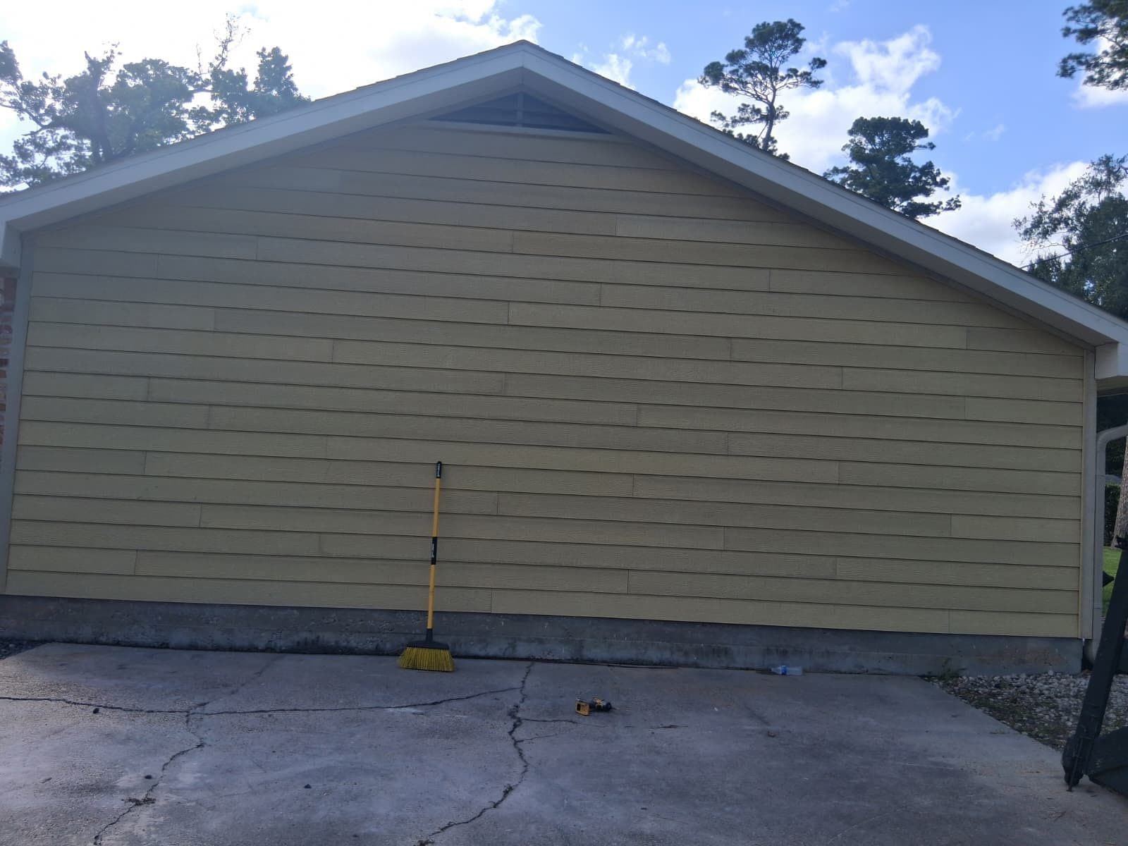 After: garage gable re-clad in fresh khaki James Hardie lap siding with white fascia