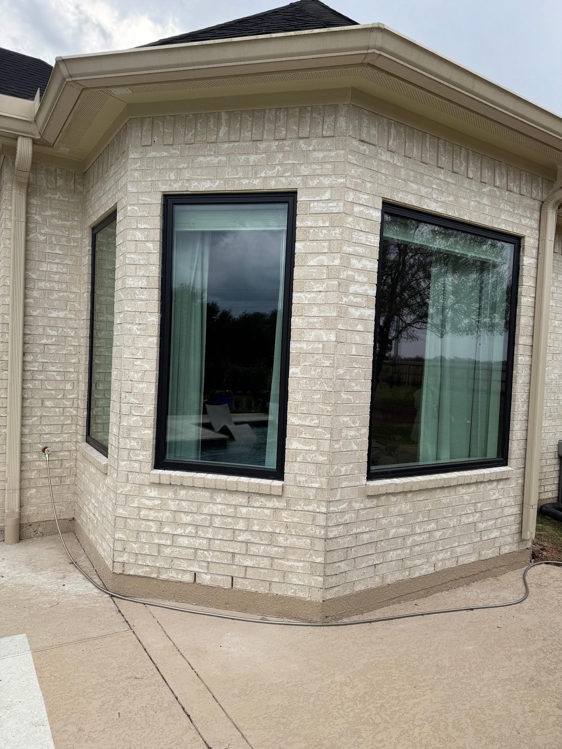 Black-framed bay window on a limestone elevation